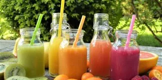 Fľaše s farebnými ovocnými smoothie na záhradnom stole